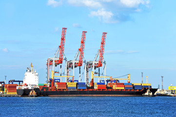 Tugboat assisting container cargo ship