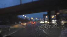 Blurred Driver View Of Motorway And Transport Driving In A Rain, Focus On Wet Windscreen