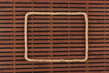 Frame of rope, lies on a background of a  bamboo mat