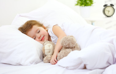 Wall Mural - child little girl sleeps in the bed with teddy bear