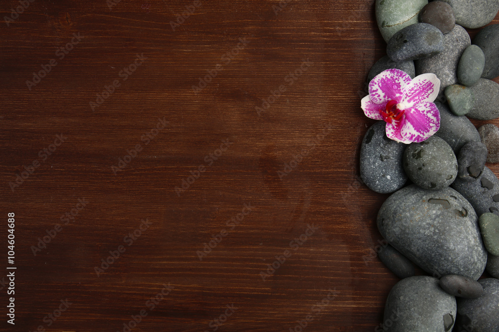Spa stones and orchid on wooden background