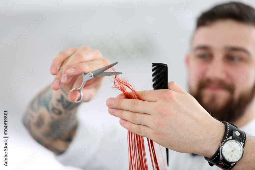 Hairdresser cutting red curls