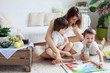 © Tomsickova - Young mother, read a book to her tho children, boys, in the livi