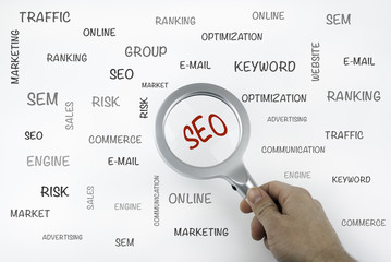 Wall Mural - sheet with text and magnifier enlarging word seo