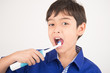 © wckiw - Little boy using electric toothbrushes on white background