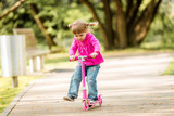 Fototapeta Młodzieżowe - little Two years old girl riding her scooter