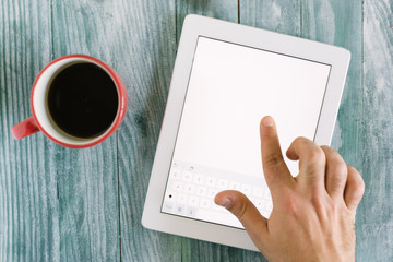 hand using mockup tablet similar to ipad style on wood desk whit