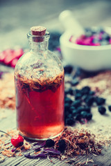 Wall Mural - Tincture bottle and mortar of healing herbs on background. Herba