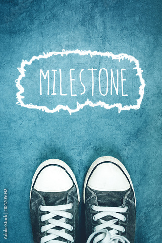 Fotografering Young man standing on the street, milestone marking on road
