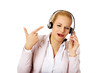 © Piotr Marcinski - Happy female phone operator pointing at headphones