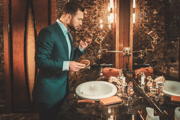 Confident well-dressed man in luxury bathroom interior.