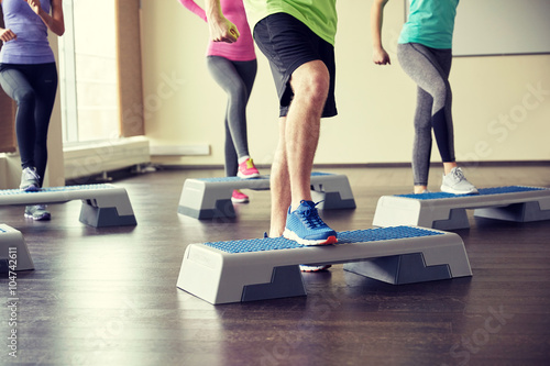 Fotomural group of people flexing legs on step platforms