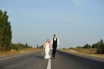 Wall Mural - Just Married Couple Walking on the Paved Road