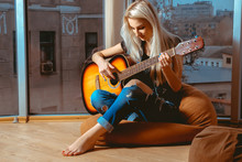 Beauty Blonde Woman Trying To Play Guitar