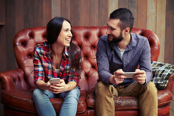 Wall Mural - couple holding smartphones and looking at each other