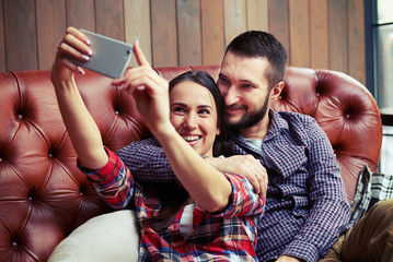 Poster - couple sitting on sofa and taking a selfie picture