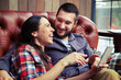 laughing couple sitting on sofa