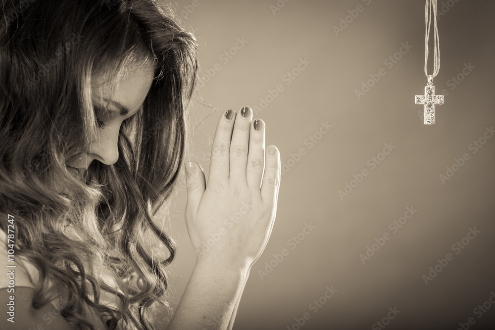 Woman praying to god jesus with cross necklace. - obrazy, fototapety, plakaty 