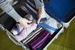 © Monet - Women are stuffed with clothes side by side in the suitcase