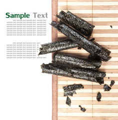 Canvas Print - Kombu and kim nori on bamboo mat over white background