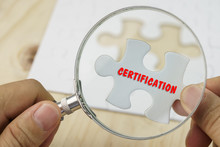Business Concept.Hand With Magnifying Glass Searching For A Piece Of Jigsaw Puzzle With CERTIFICATION Word.