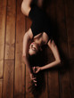 © maksimvostrikov - Seductive and passionate young charming lady in underwear with dark beautiful long hair and sexy figure is lying stretched on the wooden floor and teasing us