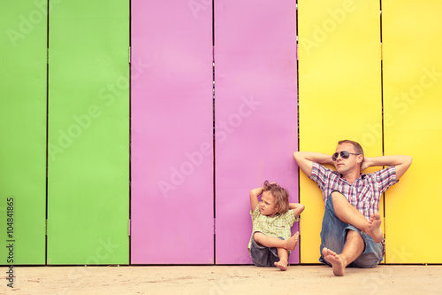 Photographie Père et fils se détendre près de la maison au moment de la journée