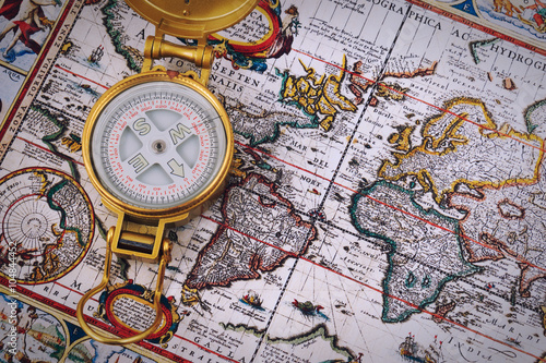 Board z aluminiowym obramowaniem Kompas i vintage mapę na drewnianym stole.