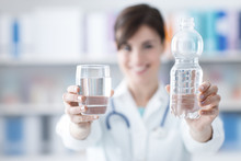 Doctor Holding A Glass Of Water And A Bottle