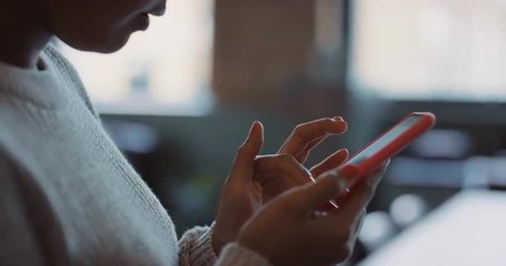 Close up of womans hands using smart phone technology to read architectural plans