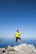 © Vitalii Nesterchuk - Man practicing trail running with a coastal landscape in the background.