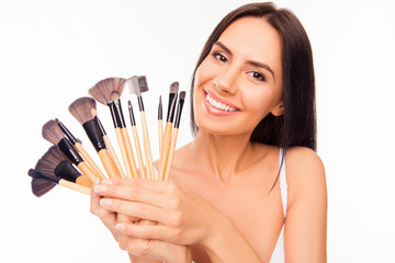 Poster - Portrait of girl with beaming smile holding makeup brushes