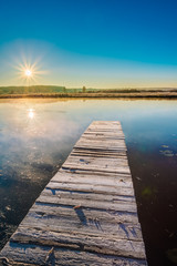 Wall Mural - Old wooden boards pier on Calm Water Of Lake, River