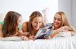 © Syda Productions - friends or teen girls reading magazine at home