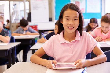 Wall Mural - Schoolgirl using tablet computer in elementary school class