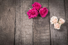 Some Cream And Pink Roses On Wooden Background