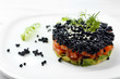 Delicious salmon tartare with black caviar on white plate