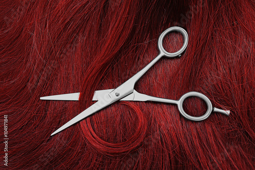 Foto Hairdresser's scissors with red hair, close up