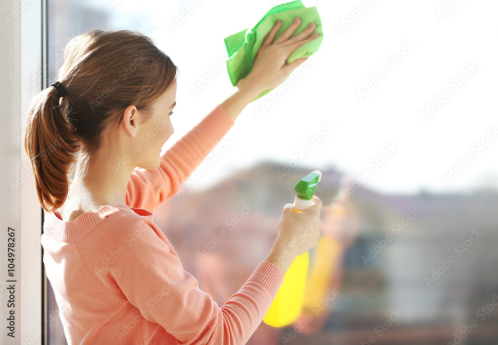 Cleaning concept. Young woman washing window, close up