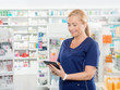 © Tyler Olson - Chemist Using Digital Tablet In Pharmacy