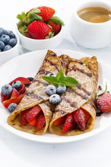 Wall Mural - crepes with berries and chocolate sauce for breakfast on plate