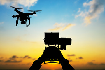 Wall Mural - man hands handling drone in sunset silhouettes