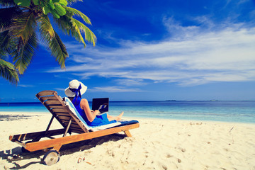 Wall Mural - young woman with laptop on tropical beach