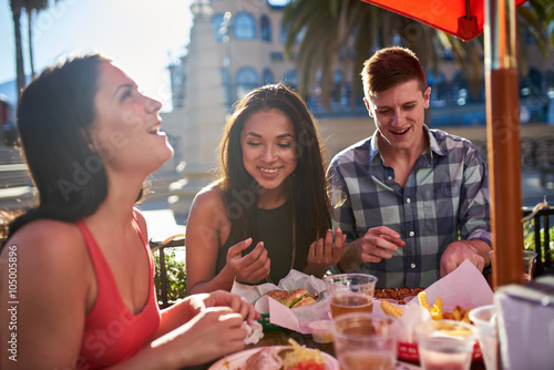Zdjęcie XXL grupa przyjaciół świetnie się bawią razem jeść obiad pod słońcem latem