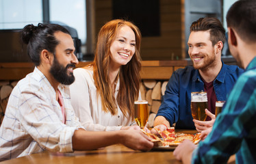 Wall Mural - friends eating pizza with beer at restaurant