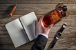 © goodmanphoto - overhead view of a man in a suit, holding a glass of whiskey