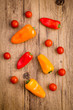 Sweet peppers and cherry tomatoes on a wooden background