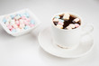 Black coffee and marshmallows on a white background