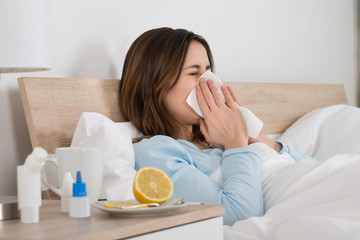 woman infected with cold lying on bed