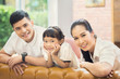 © torwaiphoto - Asian family Sitting on sofa and smiling